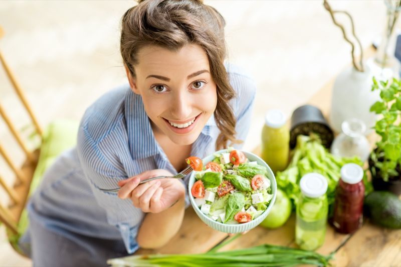 المرأة السعيدة، أكل السلطة الصحية، الجلسة على الطاولة، ب، الأخضر الطازج، المكونات، في الداخل'