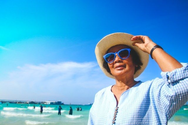 نساء مسنات يرتدين نظارة شمسية زرقاء يتجولن في البحر'