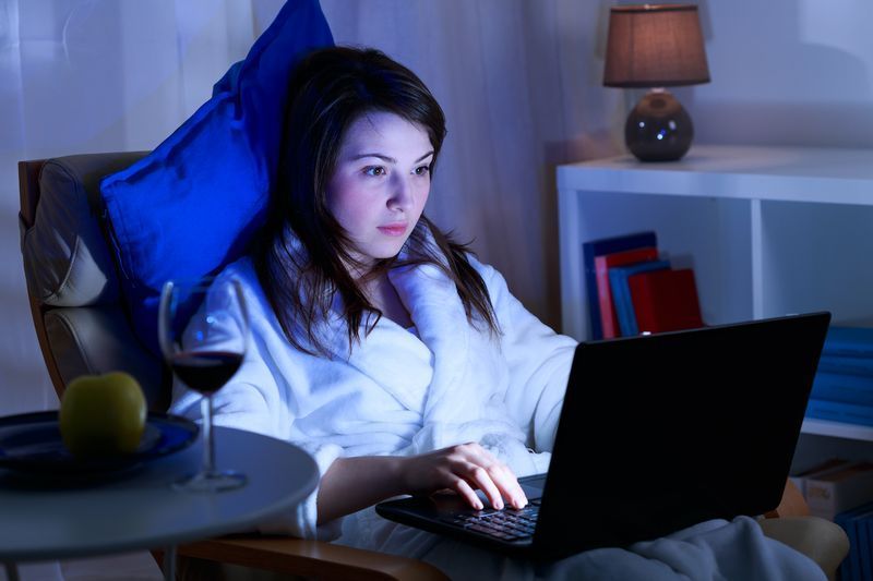 الفتاة الجذابة تقضي الوقت أمام جهاز الكمبيوتر المحمول الخاص بها'