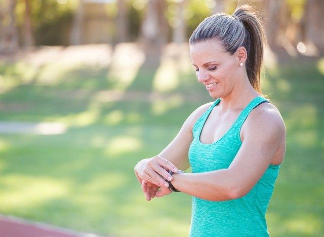 امرأة تنظر إلى الساعة قبل الجري - كيفية إنقاص الوزن بعد 30'