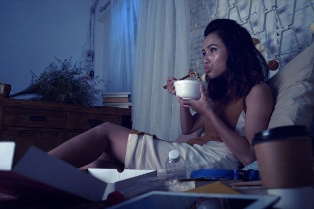امرأة تأكل حساء الرامين ومشاهدة المسلسلات في وقت متأخر من الليل'