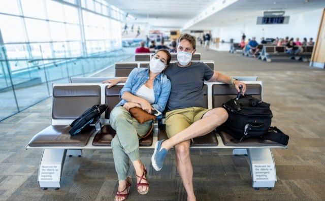 زوجين مع قناع الوجه عالق في محطة المطار'