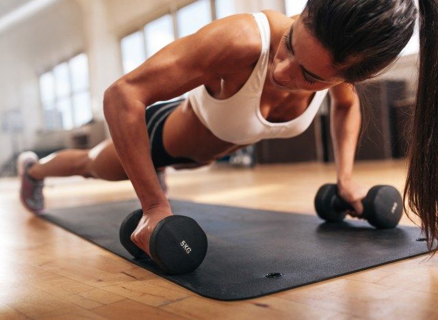 امرأة ذات أذرع عضلية قوية تؤدي تمارين الضغط من أجل التمرين'