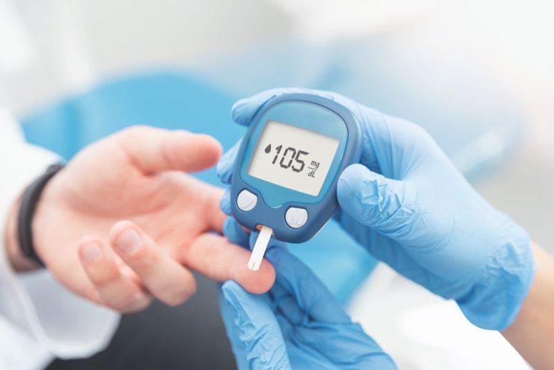 يقوم الطبيب بفحص مستوى السكر في الدم باستخدام جهاز قياس السكر. علاج مرض السكري.'