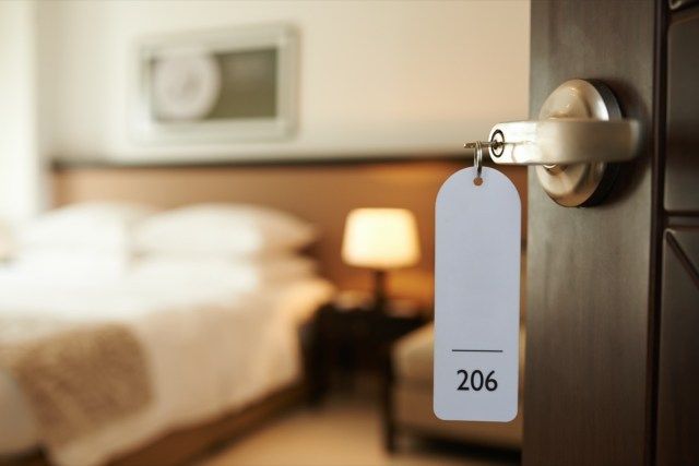 باب غرفة فندق مفتوح مع مفتاح في القفل'