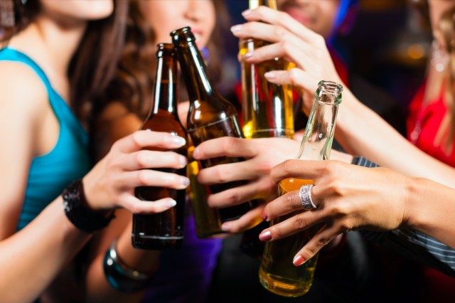 مجموعة من أعضاء الحزب - رجال ونساء - يشربون البيرة في حانة أو حانة'