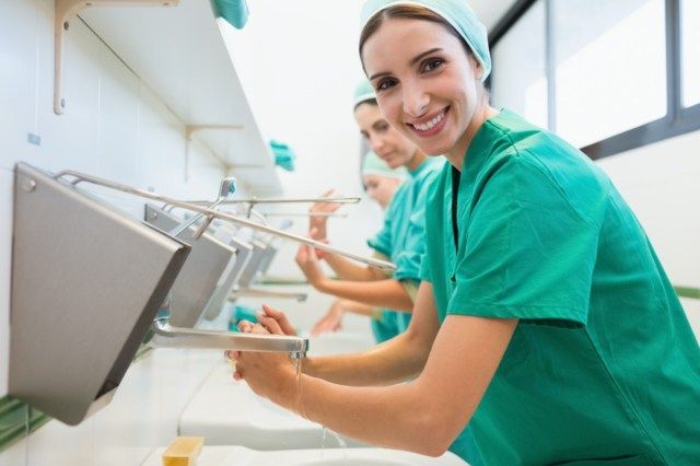 يغسل الجراحون أيديهم في المستشفى وهم يبتسمون'