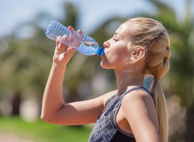 امرأة تشرب من زجاجة ماء بلاستيكية'