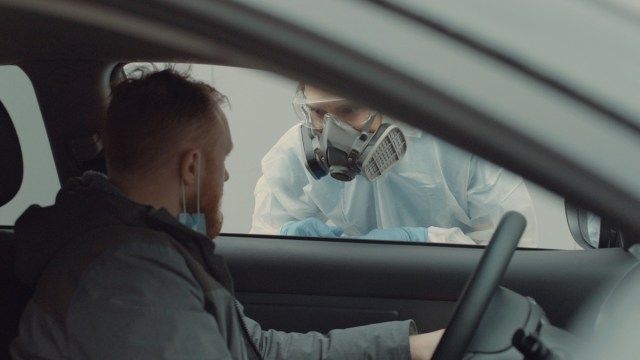 يتم اختبار المريض في سيارته في موقع اختبار فيروس كورونا COVID-19'
