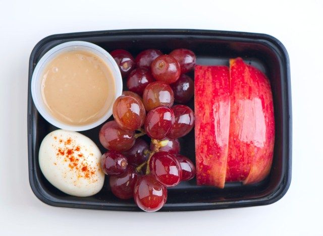 علبة بروتين سناك مع زبدة الفول السوداني والبيض والعنب والتفاح'