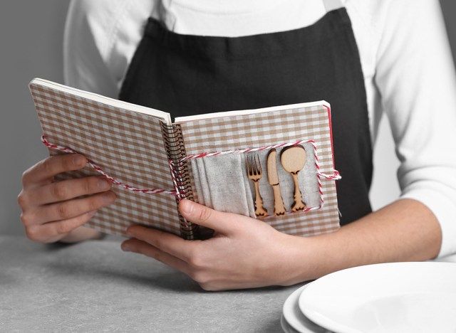 امرأة تحمل كتاب طبخ'