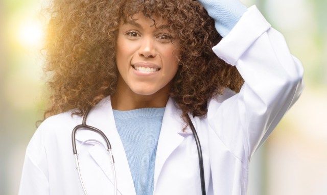 امرأة أمريكية من أصل أفريقي طبيبة تلمس شعرها'