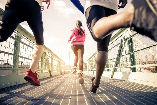 ثلاثة عدائين يركضون في الهواء الطلق - تدريب الأشخاص الرياضيين في منطقة حضرية ونمط حياة صحي ومفاهيم رياضية'
