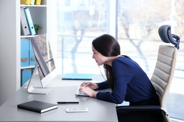 امرأة شابة تعمل مع الكمبيوتر في المكتب'