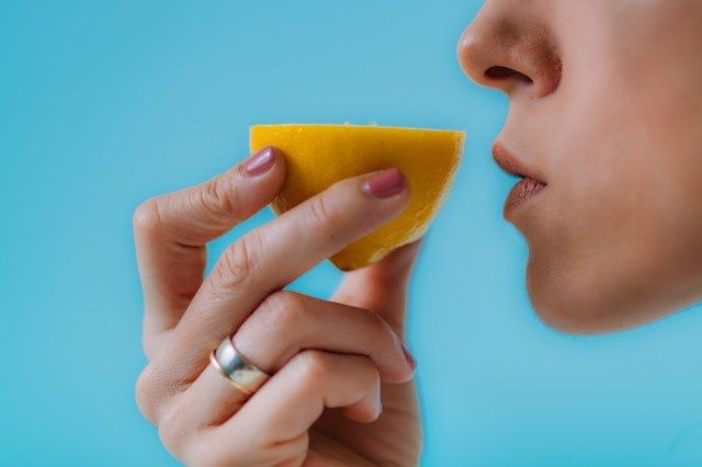 امرأة تحاول أن تستشعر رائحة الليمون'