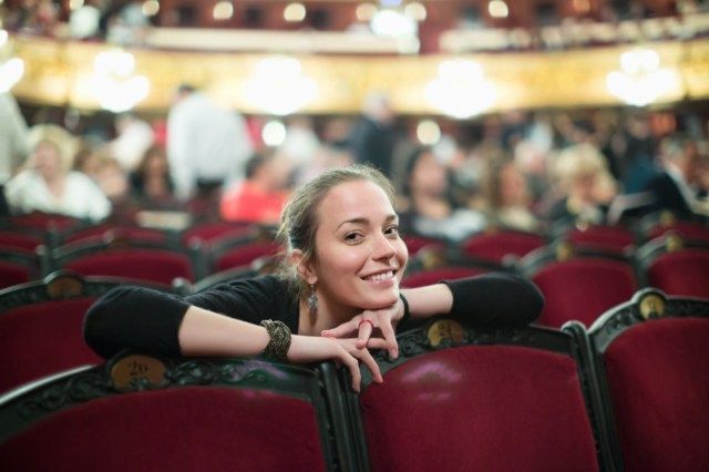 صورة لامرأة مبتسمة في قاعة مسرح الأوبرا'