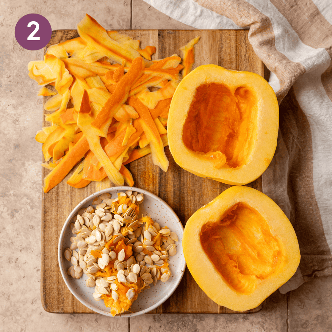 Pumpkin halves, peels and seeds on a wooden cutting board.