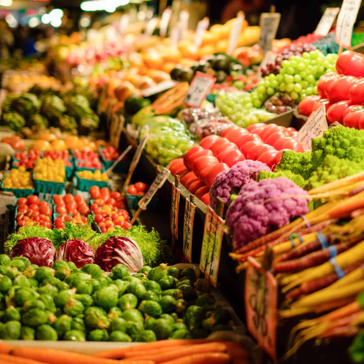 vegetables lined up on a table at an outdoor market.