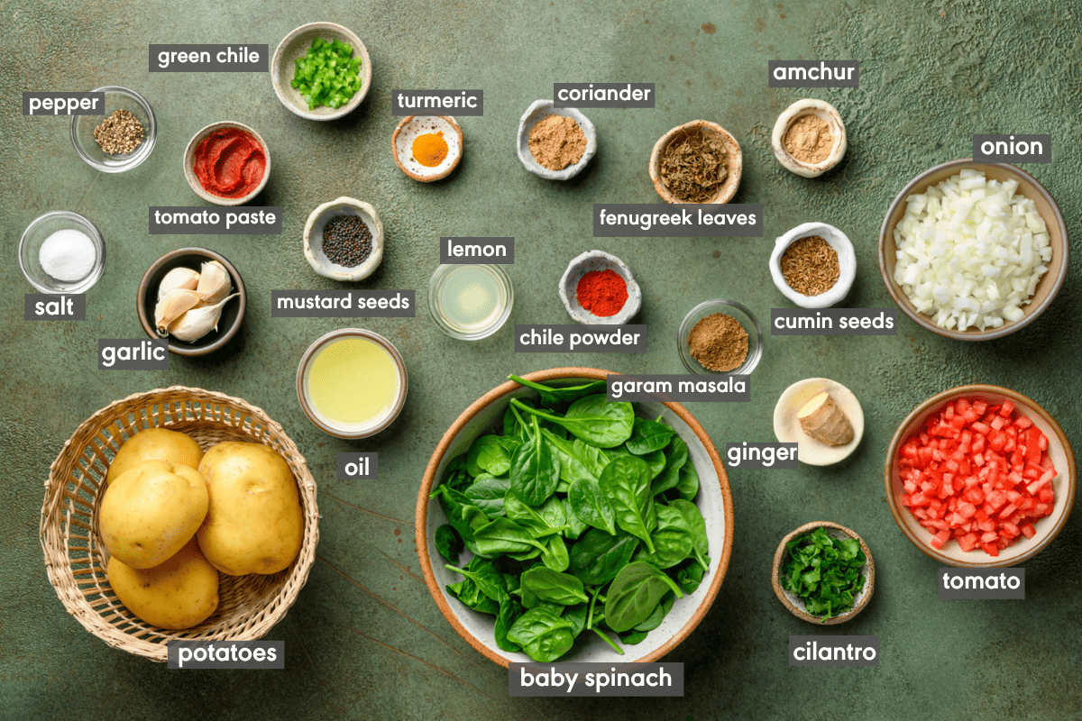 ingredients for Indian dish saag aloo laid out in bowls and labeled. 